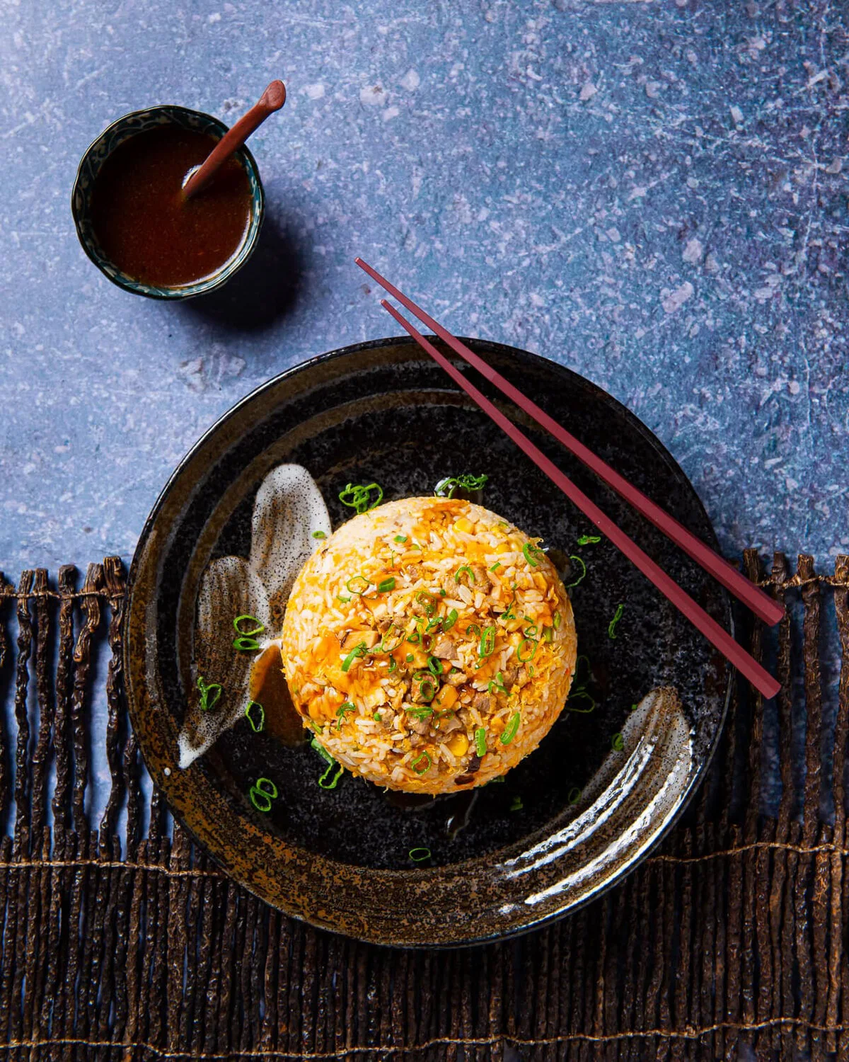 Fu Jian-style fried rice on a dark plate beside chopsticks.