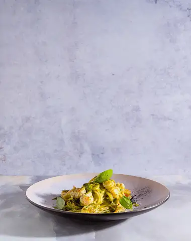 Animated food plating sequence against a pale backdrop.