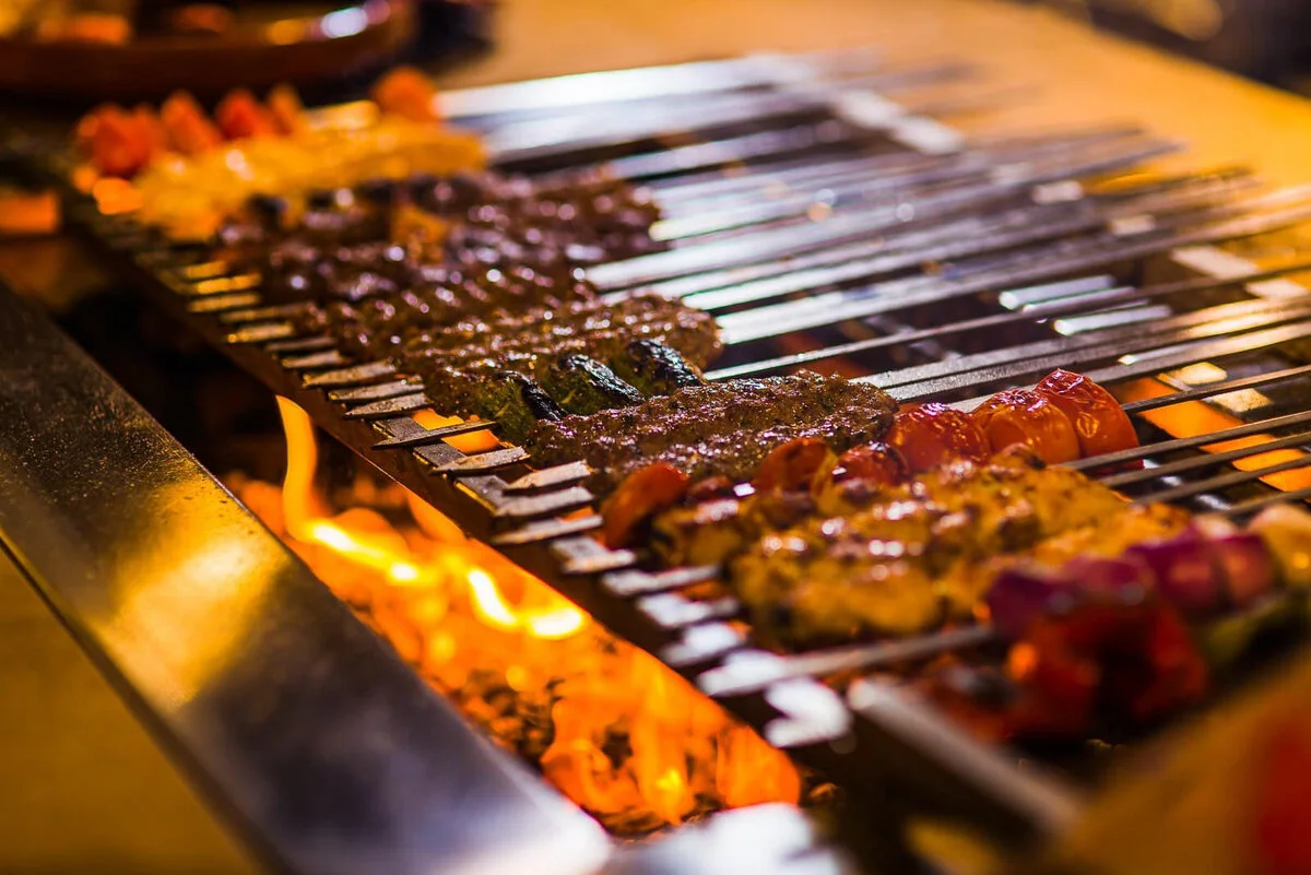 Rows of skewers cooking over a grill.