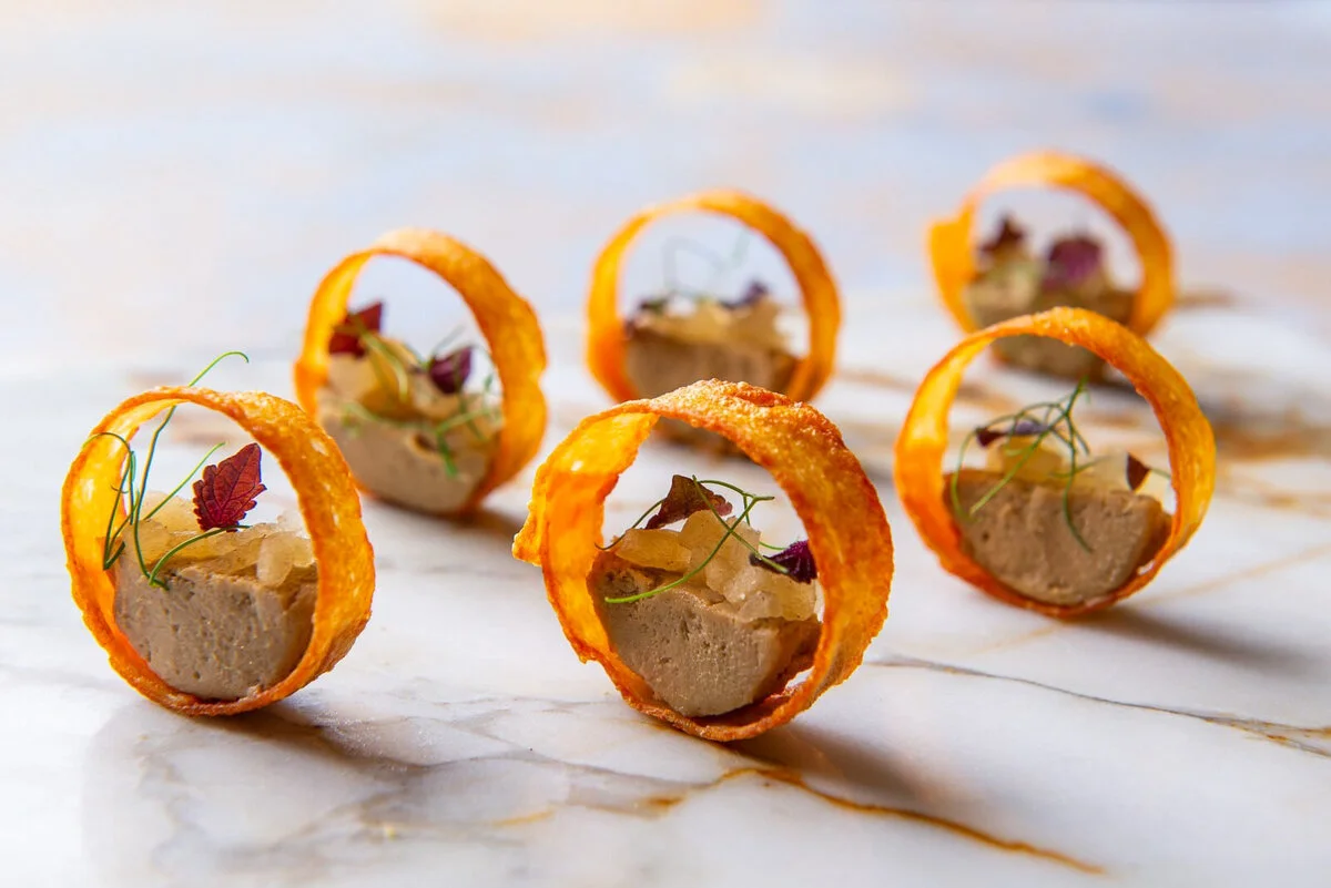 Three filled pastry rings on a white platter.