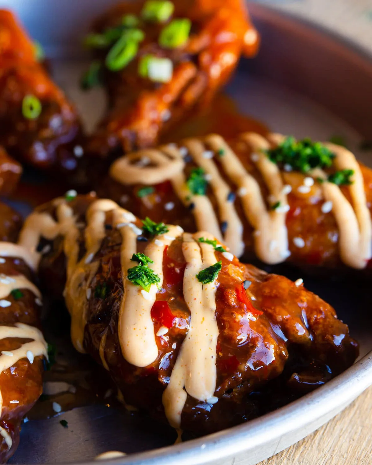 Sticky Korean chicken wings drizzled with sauce.
