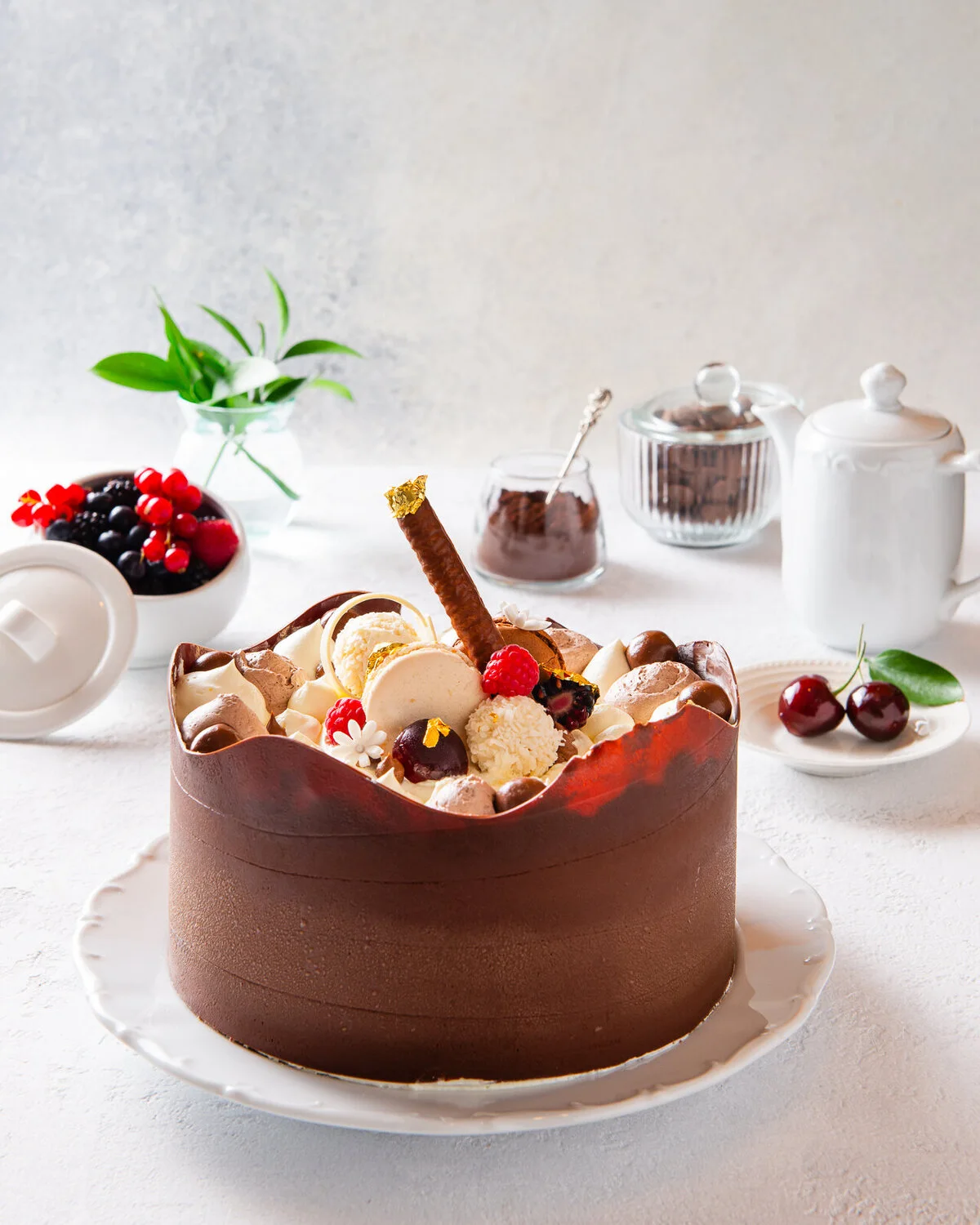 Chocolate cake decorated with fruit and chocolate pieces.