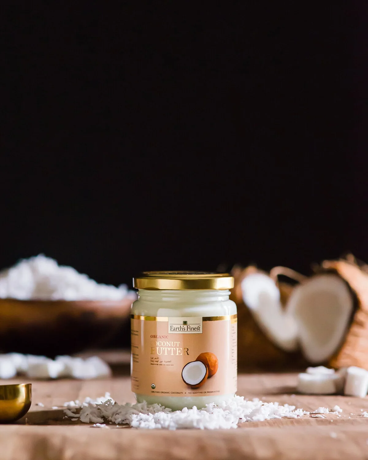 Earth's Finest coconut butter jar beside an opened coconut.