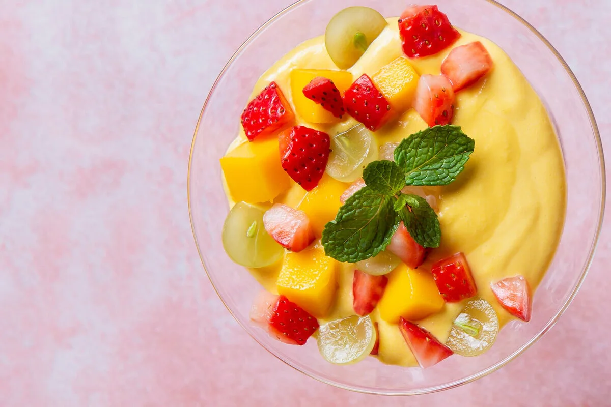Mango sago pudding topped with fruit and mint.