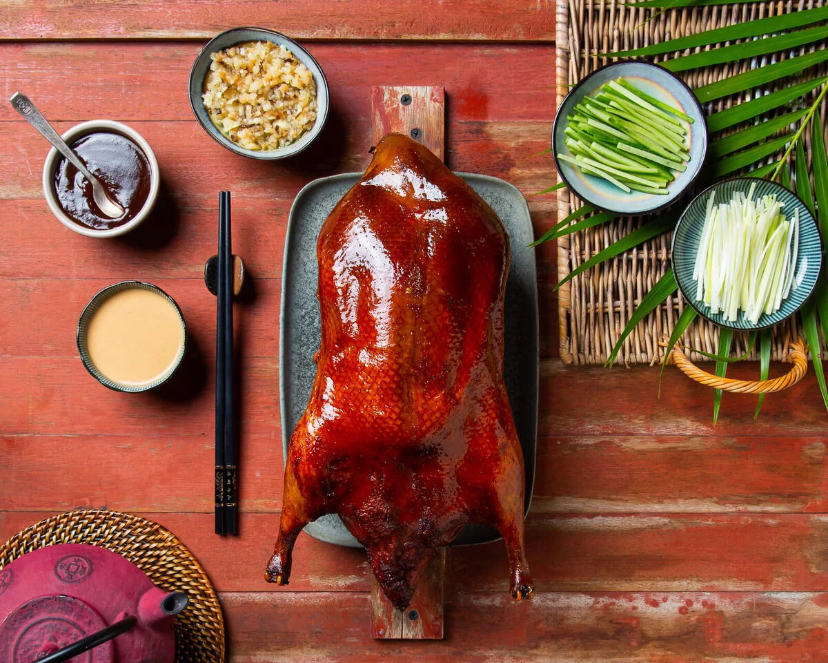 Whole Peking duck with sauces, cucumber sticks and scallions.