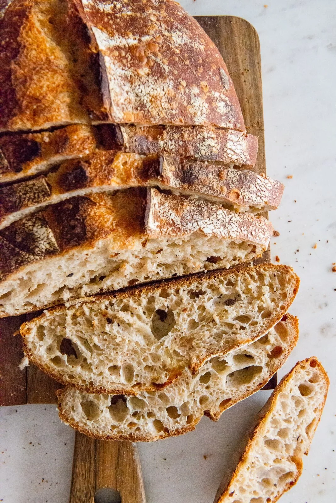 Sliced rustic bread arranged on a pale surface.